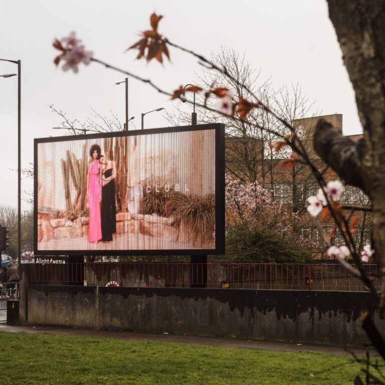 A large roadside digital billboard beside a busy road