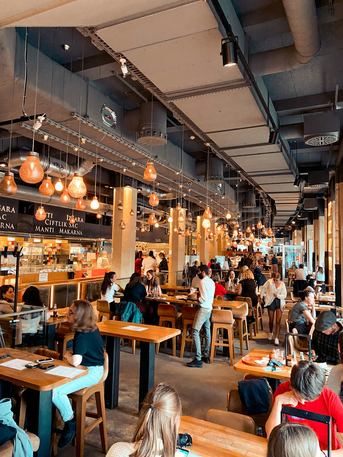 A busy restaurant full of people eating and drinking