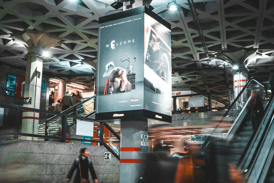 A digital screen beside escalators in a busy metro station